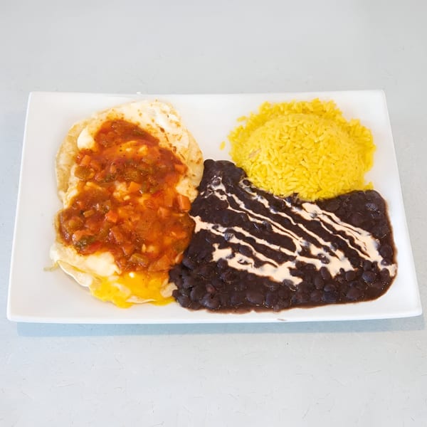 Huevos rancheros with salsa, black beans drizzled with cream, and yellow rice on a white plate.